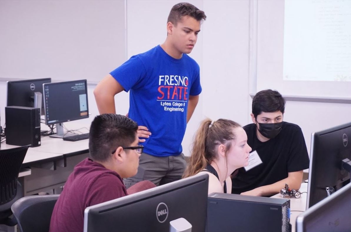 Nicholas Amely assisting students working on a computer