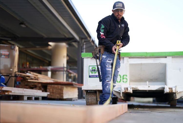 Carlos Antonio measuring a piece of wood