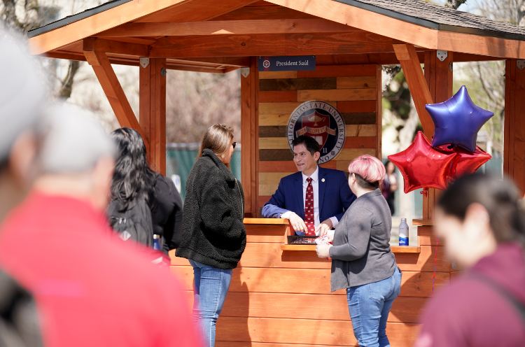 Preisdent Jimenez-Sandoval speaking with students at his booth