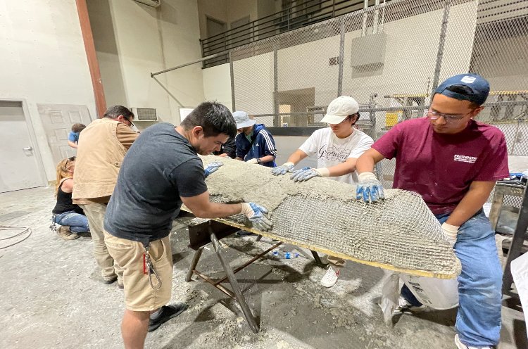 Civil engineering students constructing a concrete canoe