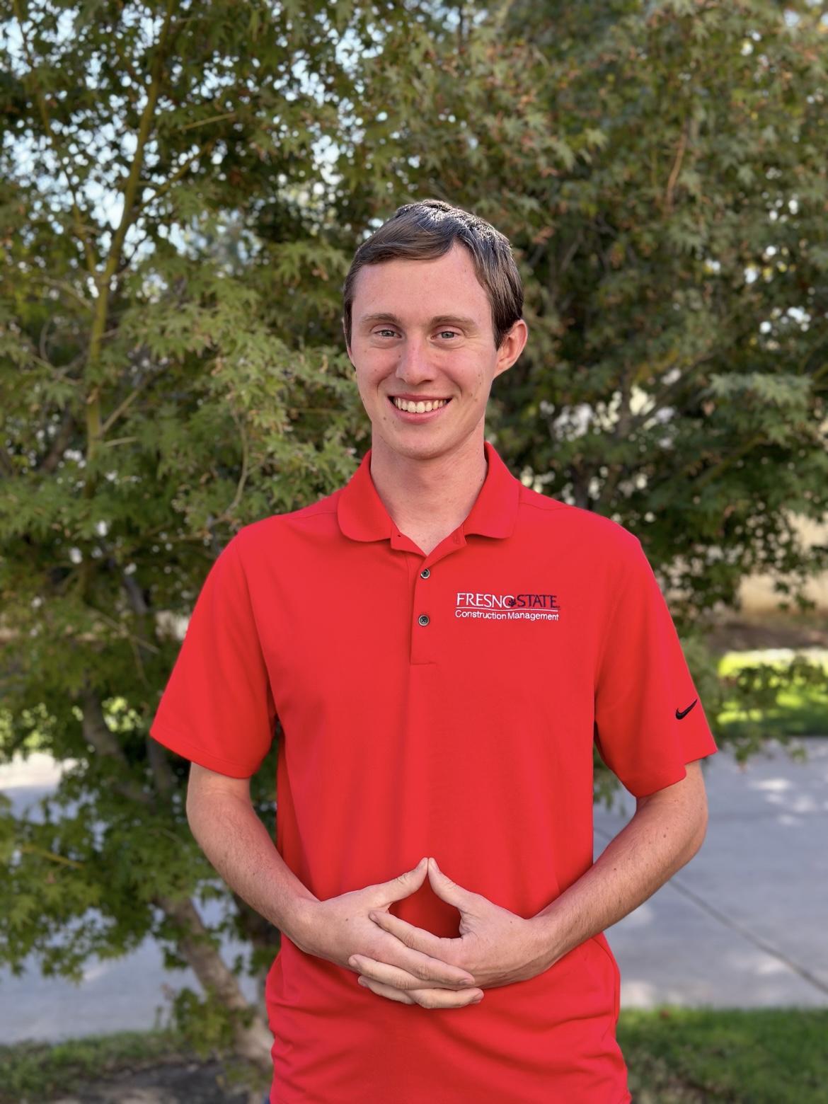 Matthew posing in a red Fresno State polo