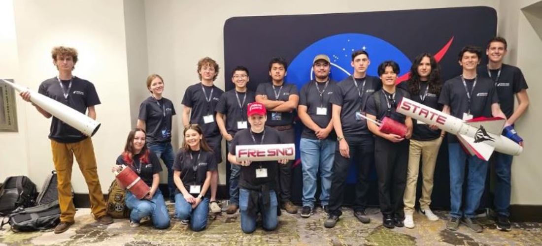 Students hold rockets while standing together at a NASA challenge 
