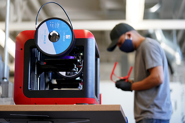 Machine in focus with student in background