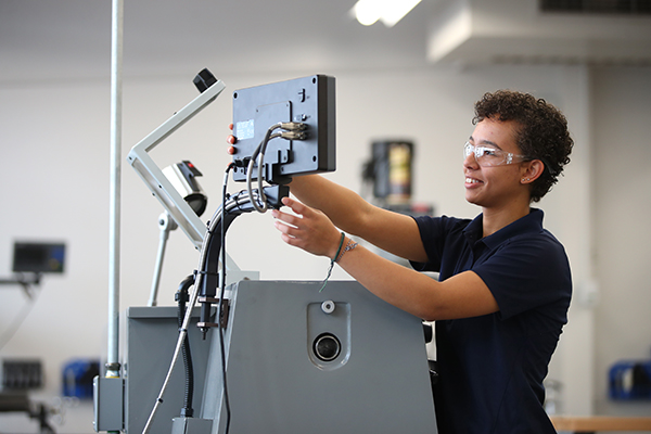 Student Adjusting a Machine 